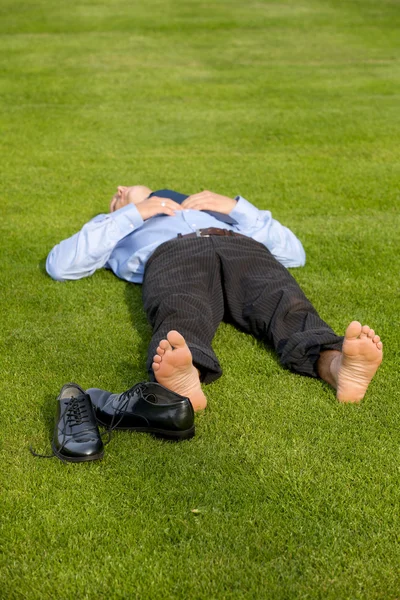 Podnikatel relaxace v parku — Stock fotografie