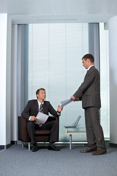 Businessman giving paper to colleague — Stock Photo, Image