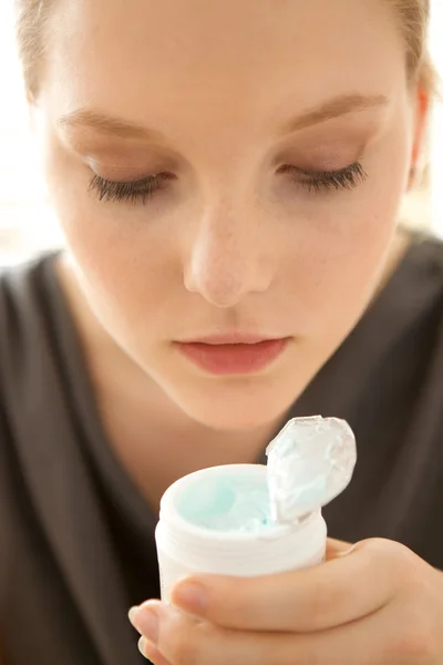 Vrouw bedrijf gezicht reinigingsmiddel — Stockfoto