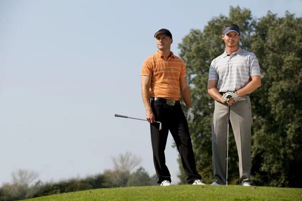 Män som stod med golf klubbor — Stockfoto