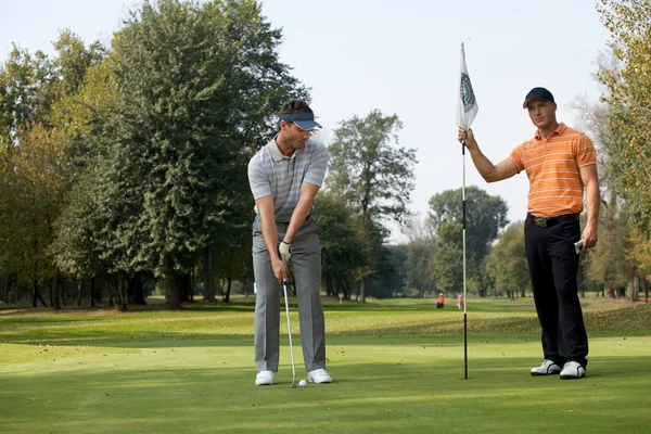 Mannen permanent met golf stokken — Stockfoto