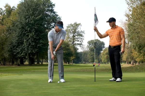 Homem com amigo jogando golfe — Fotografia de Stock