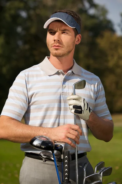 Junger Mann steht neben Golftasche — Stockfoto