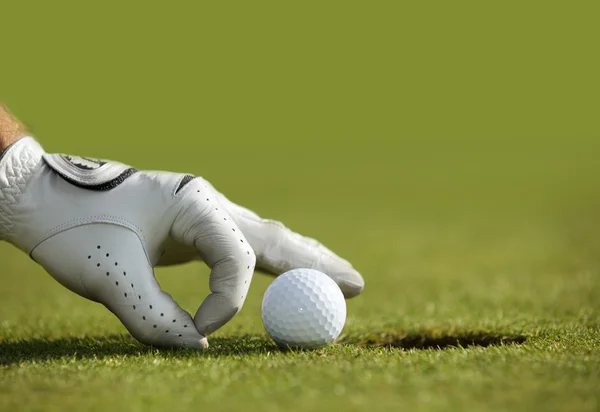 Mano mettendo una palla da golf — Foto Stock