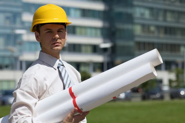 Arquitecto en hardhat sosteniendo plano — Foto de Stock