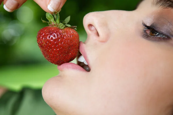 Jonge vrouw die aardbeien eet — Stockfoto