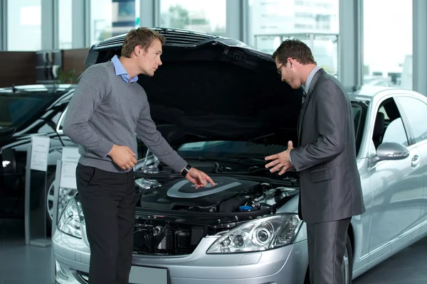 Verkäufer erklärt den Motor des Autos — Stockfoto