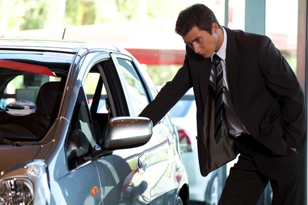 Vendedor olhando para o carro novo — Fotografia de Stock