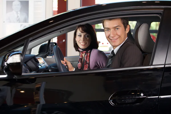 Couple sitting in a new car — Stock Photo, Image