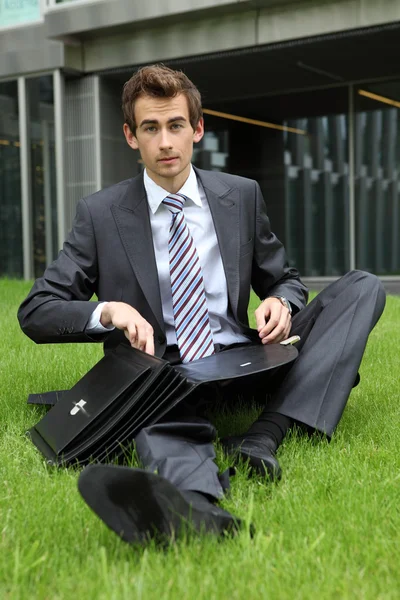 Businessman sitting on grass — Stock Photo, Image