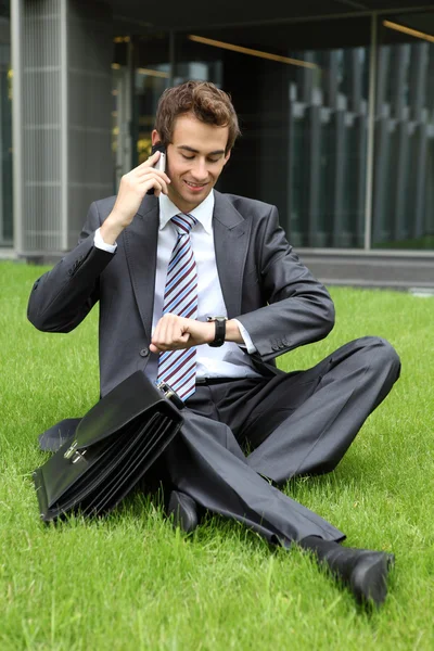 草の上に座っての実業家 — ストック写真