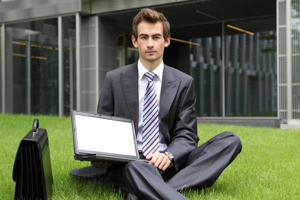 Podnikatel, sedět na trávě — Stock fotografie