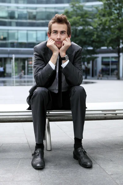 Podnikatel sedí na lavičce — Stock fotografie