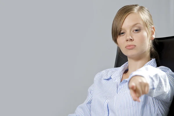 Young businesswoman pointing in office — Stock Photo, Image