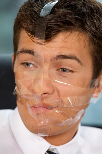 Businessman with tape on his face — Stock Photo, Image