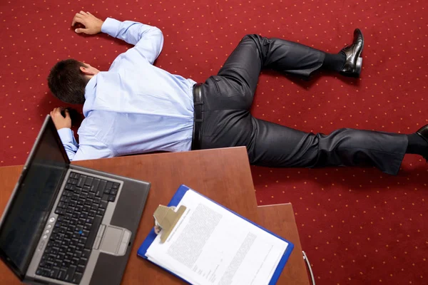 Geschäftsmann liegt im Büro — Stockfoto