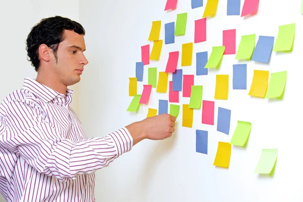 Empresário segurando notas pegajosas — Fotografia de Stock