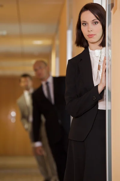 Businesswoman standing on door — Stock Photo, Image