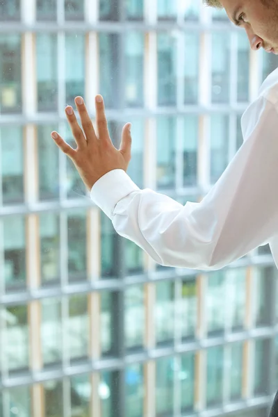 Homme d'affaires debout contre la fenêtre — Photo