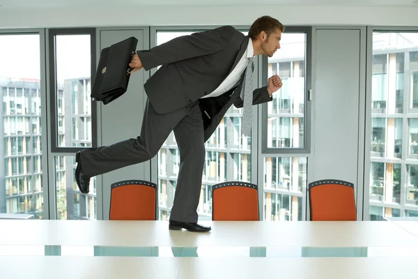 Бизнесмен бежит по офисному столу — стоковое фото