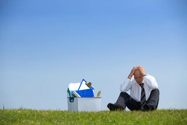 Businessman sitting next to basket — Stock Photo, Image