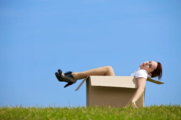 Mulher relaxante em caixa de papelão — Fotografia de Stock