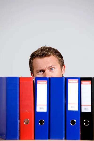 Businessman sitting behind files — Stock Photo, Image