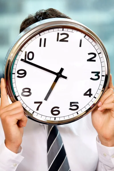 Businessman holding clock Stock Picture