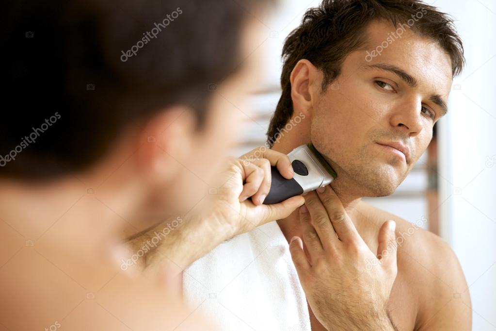 man shaving with electric shaver
