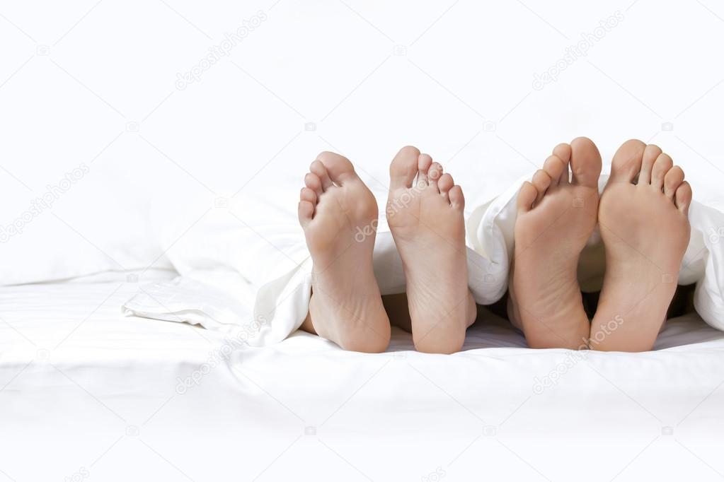 Feet of a couple on the bed