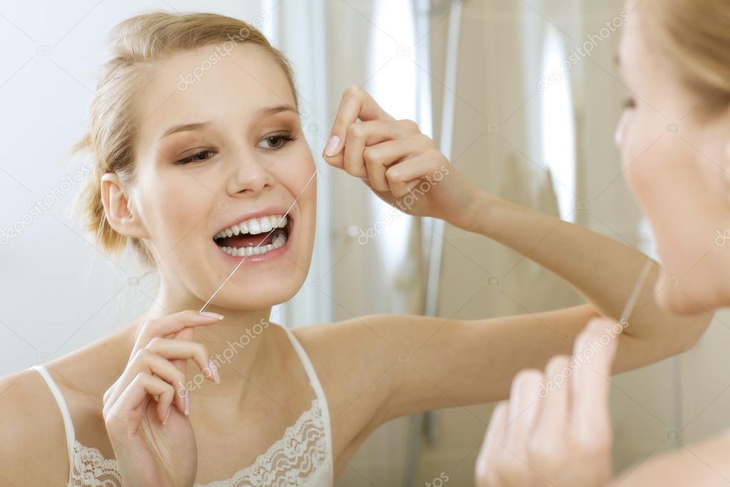 Woman flossing her teeth