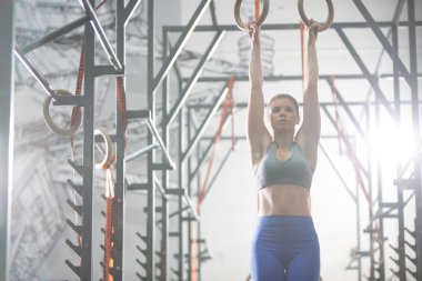 Jimnastik yüzükleriyle egzersiz yapan bir kadın.