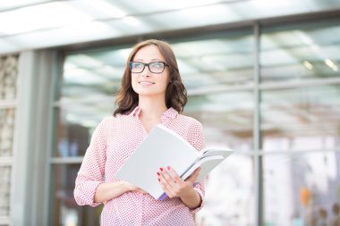 woman looking away while holding books