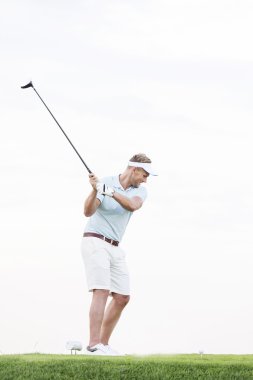 Golf sopası sallayan adam.