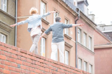 couple with arms outstretched walking