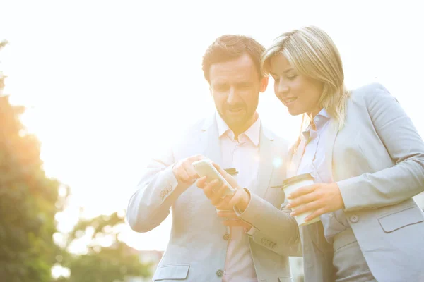 Couple conversing while using cell phone — Stok fotoğraf