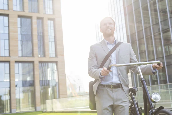 Homme d'affaires debout avec vélo — Photo