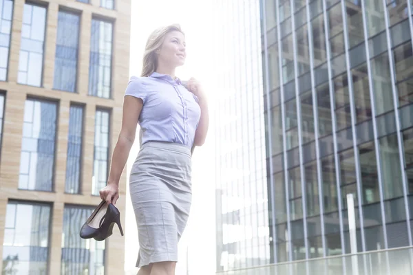 Mujer de negocios sosteniendo tacones altos — Foto de Stock