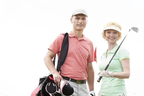 Male and female golfers standing — Stok fotoğraf