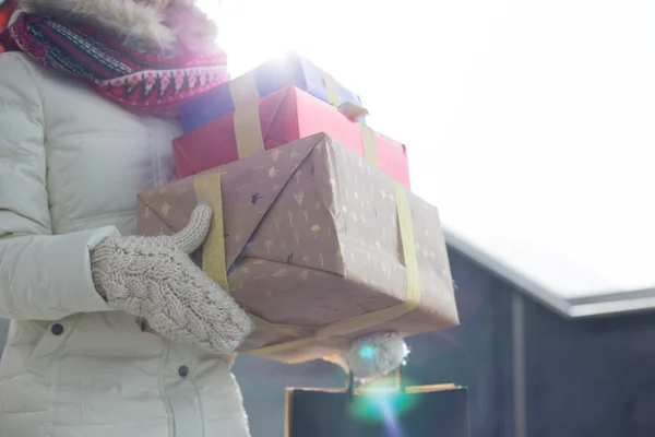 Woman carrying stacked gifts — Stock Photo, Image