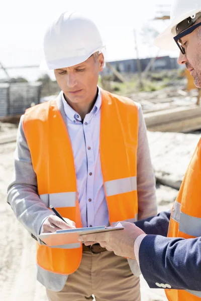 Ingenieros escribiendo en portapapeles — Foto de Stock