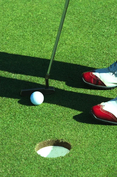Personne mettant la balle de golf — Photo