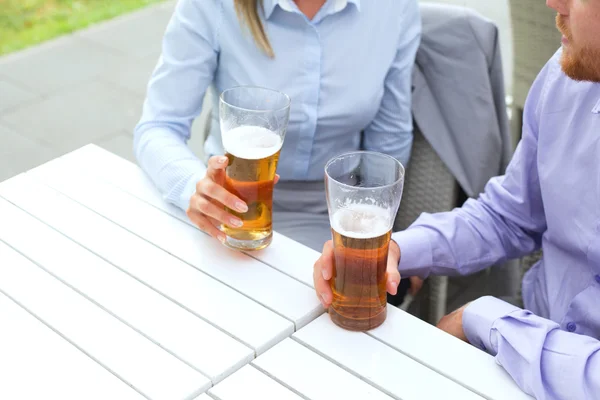 Casal de negócios segurando copos de cerveja — Fotografia de Stock