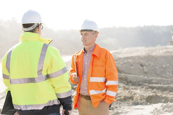 Arbetsledare diskuterar på byggarbetsplats — Stockfoto