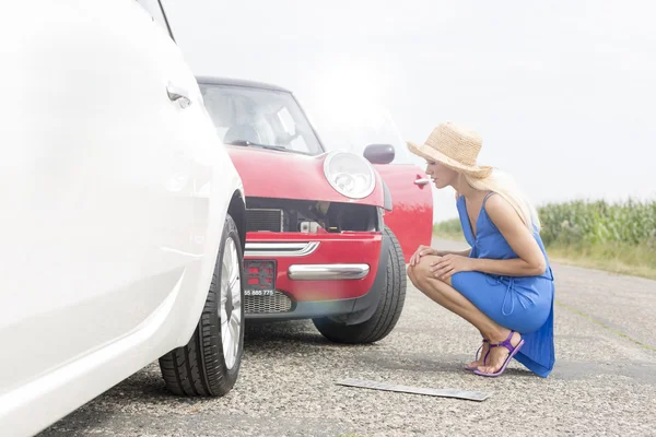 Woman looking at damaged cars — Stock Photo, Image