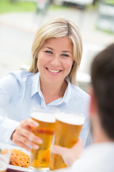 Businesswoman toasting beer glass — Stockfoto