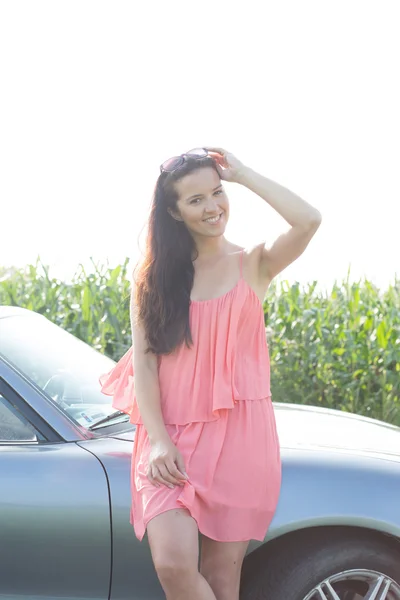 Woman leaning by convertible — Stock Photo, Image