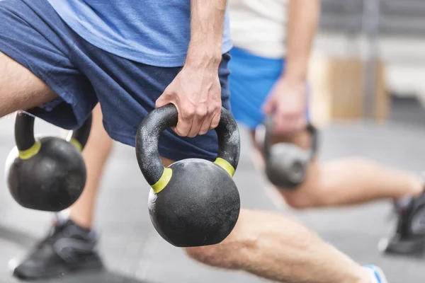 Homens levantando kettlebells — Fotografia de Stock