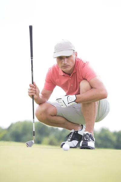 Man aiming ball while crouching — Stock Photo, Image