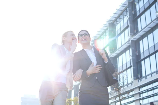 Businesswoman whispering in colleague's ear — Stok fotoğraf